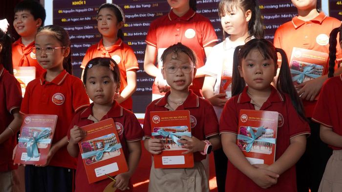 Các em học sinh tiểu học Vạn Xuân hào hứng đón nhận giải thưởng từ cuộc thi viết về "Trường học hạnh phúc" cấp trường.