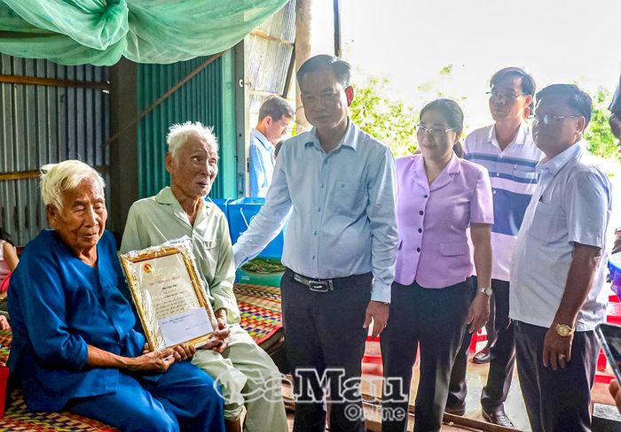 Phó Chủ tịch Uỷ ban MTTQ Việt Nam tỉnh Cà Mau Nguyễn Văn Khởi trao Thiếp chúc mừng và quà của Chủ tịch nước đến cụ ông Bùi Văn Thế (100 tuổi, Ấp Trần Hợi, Xã Trần Văn Thời).