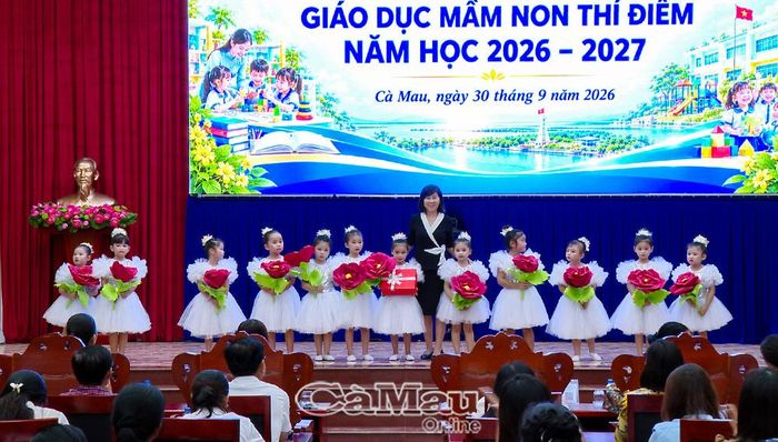 Phó Giám đốc Sở GD&ĐT tỉnh Cà Mau Nguyễn Hồng Nhung tặng quà các bé Trường Mầm non Hoa Hồng (xã Hoà Bình) sau tiết mục biểu diễn tại hội thảo.