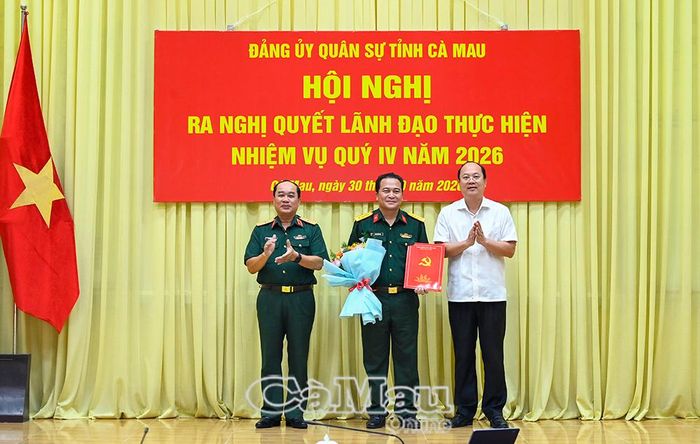 Đồng chí Nguyễn Hồ Hải, Bí thư Tỉnh uỷ, Bí thư Đảng uỷ Quân sự tỉnh và Thiếu tướng Nguyễn Văn Ngành, Phó Bí thư Đảng uỷ Quân sự tỉnh, Chỉ huy trưởng Bộ CHQS tỉnh, trao quyết định và tặng hoa chúc mừng Đại tá Trần Quốc Dẹn.