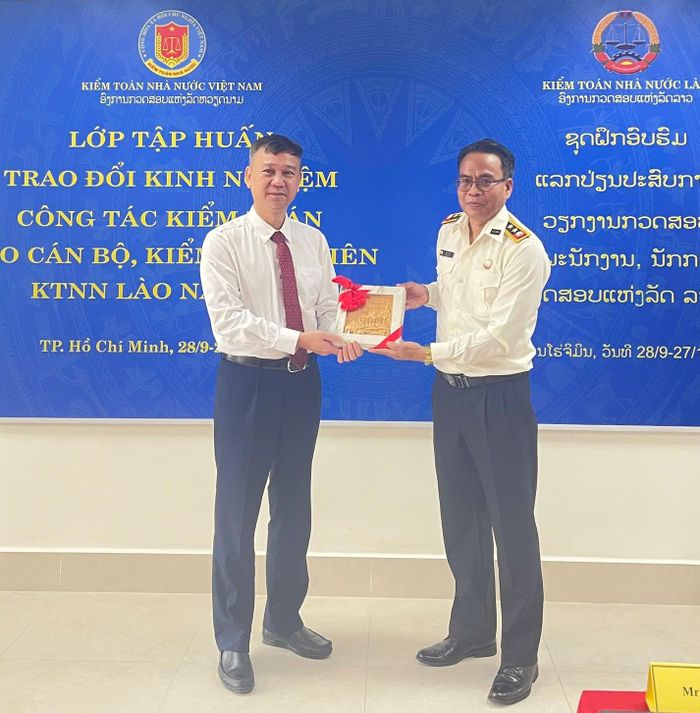 Ông Kham ASAY - Vụ trưởng KTNN Lào khu vực II (bên phải) tặng quà lưu niệm Trường Đào tạo và Bồi dưỡng nghiệp vụ kiểm toán. Ảnh: CTV