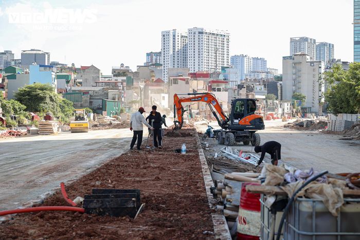 Tại nhiều vị trí khác, công nhân tập trung hoàn thiện dải phân cách, trong khi cây xanh, cây bóng mát được tập kết để chuẩn bị trồng. 