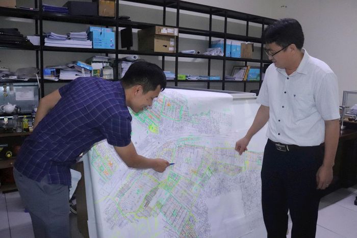 Cán bộ Phòng Kinh tế xã Mê Linh đánh dấu những thửa đất đã được làm sạch. Ảnh: Hoàng Sơn