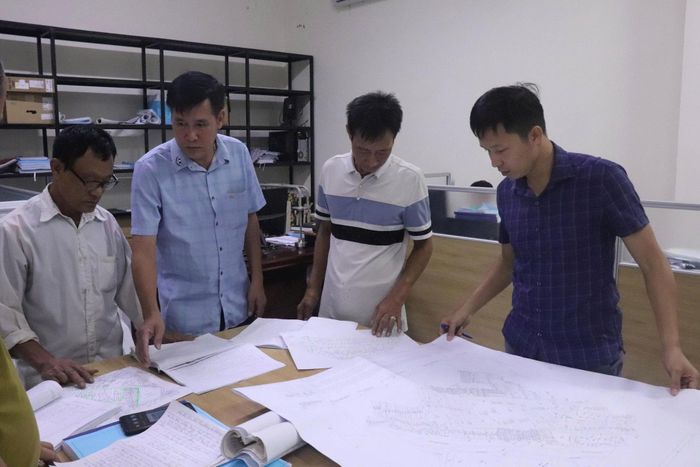 Tổ công tác rà soát các thửa đất trên bản đồ. Ảnh: Hoàng Sơn