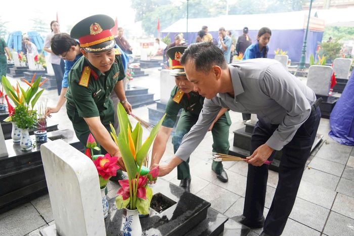Bí thư Đảng ủy, Chủ tịch HĐND phường Chương Mỹ Phí Minh Hải cùng cán bộ, chiến sĩ và nhân dân địa phương thắp hương tại phần mộ liệt sĩ trước khi thực hiện khai quật, lấy mẫu. Ảnh: Lan Oanh