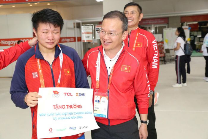 Trưởng đoàn Thể thao Việt Nam Nguyễn Hồng Minh trao thưởng cho tấm Huy chương đồng của Lưu Diễm Quỳnh. Ảnh: Bùi Lượng