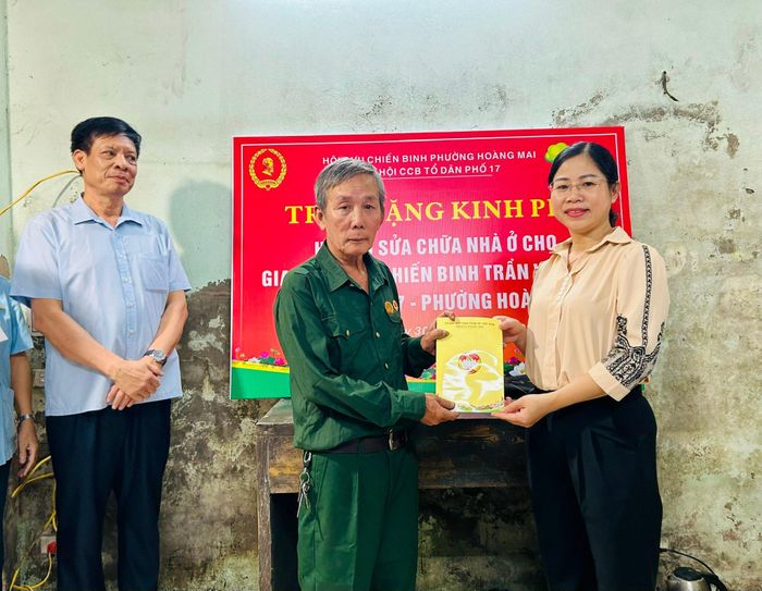 Chủ tịch Hội LHPN phường Hoàng Mai Nguyễn Thị Kim Thu đại diện trao hỗ trợ cho cựu chiến binh Trần VănTiến. Ảnh: Trần Oanh.