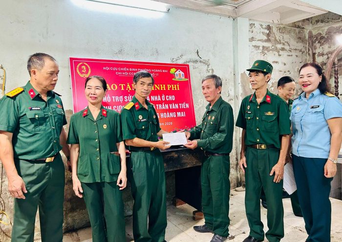 Chi hội trưởng Chi hội Cựu chiến binh Tổ dân phố số 17 Trần Quốc Hương gửi tặng món quà nghĩa tình tới hội viên Trần Văn Tiến. Ảnh: Trần Oanh.