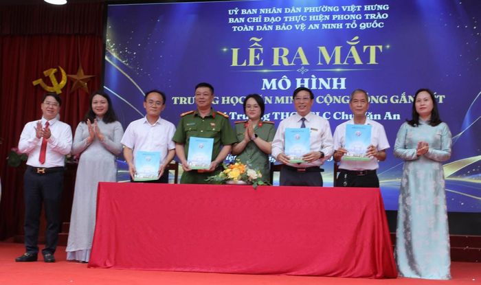 Đại diện Công an phường, tổ dân phố, Ban giám hiệu và Ban đại diện cha mẹ học sinh Trường THCS Chu Văn An ký cam kết phối hợp bảo đảm an ninh, trật tự trường học. Ảnh: PV