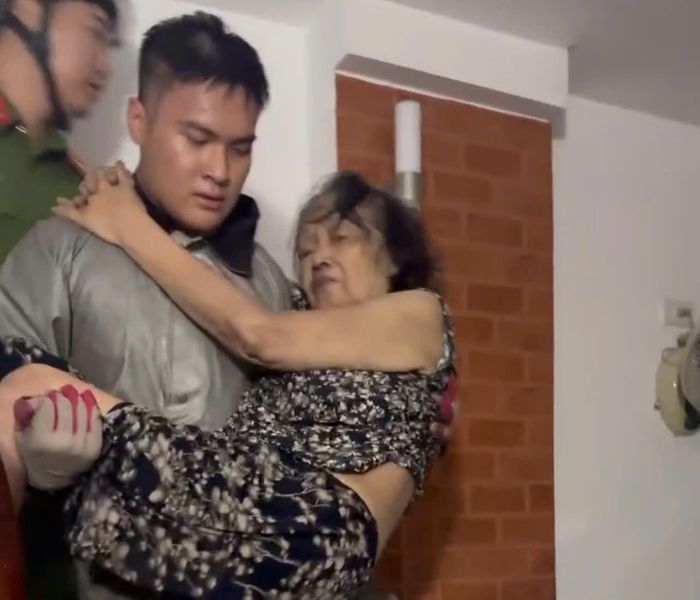 Hạ sĩ Hoàng Hải Long trực tiếp bế bà cụ thoát khỏi đám cháy trên phố Đội Nhân. Ảnh: Bảo Hân