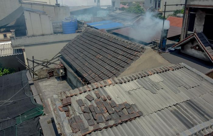 Khói thải nghi ngút bốc ra từ ống khói của một xưởng cô đúc nhôm thủ công giữa khu dân cư đông đúc tại thôn Bình Yên.