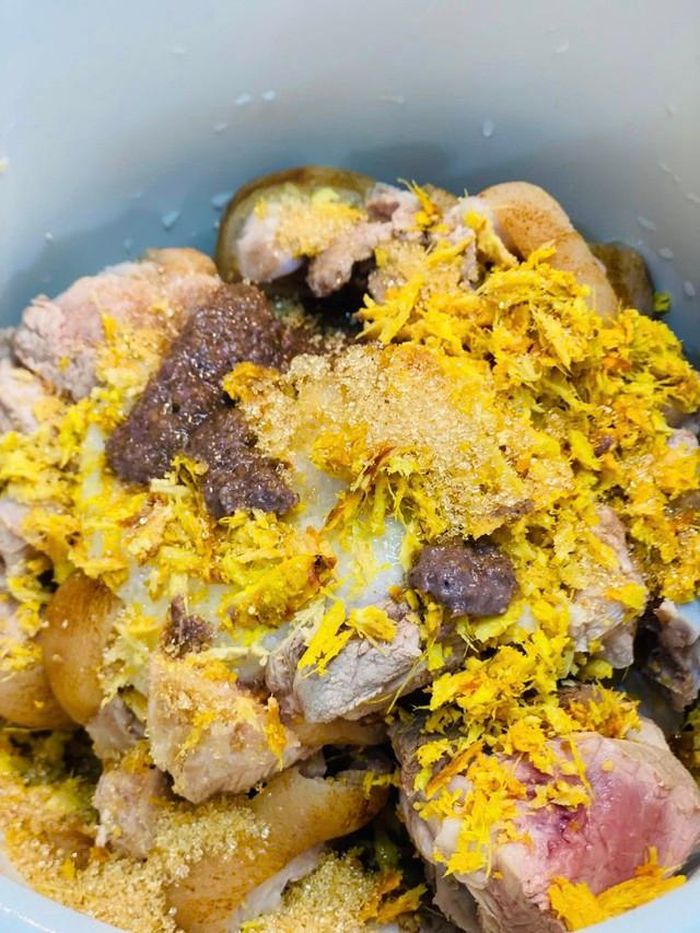 2. Ướp thịt: Trộn chân giò với mẻ, mắm tôm, nước mắm, riềng, nghệ, tỏi, hành băm, đường, hạt nêm. Để ngấm khoảng 30 phút đến 1 tiếng. Nếu có thời gian để ướp non nửa buổi càng thấm, thịt càng ngon, còn vào mùa hè thì bọc màng bọc thực phẩm để ngăn mát tủ lạnh.