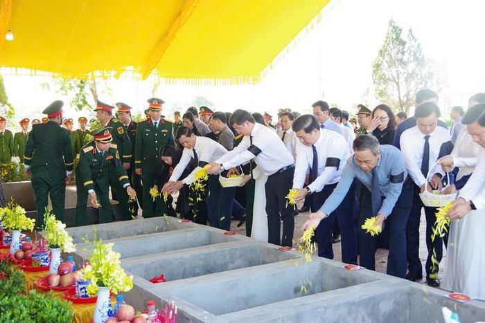 Đại biểu cùng lực lượng danh dự đưa các hài cốt liệt sĩ về khu vực an táng. Ảnh: Xuân Diện.