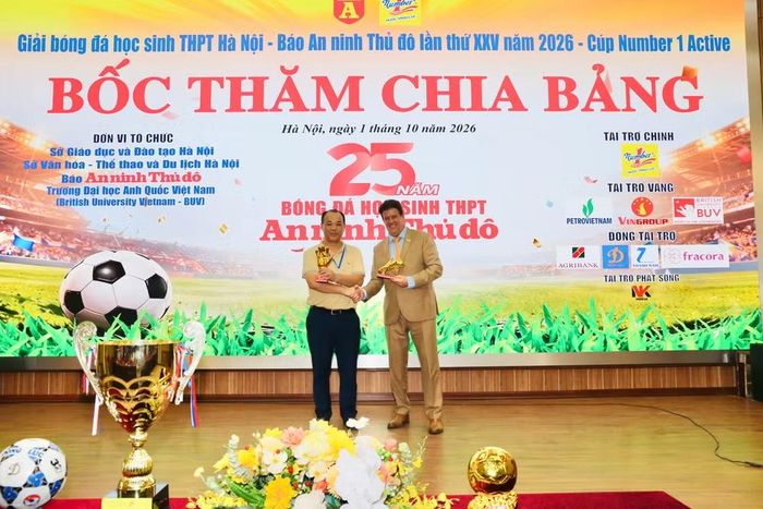 GS.TS Rick Bennett - Phó Hiệu trưởng Trường Đại học Anh Quốc Việt Nam – Bristis Univercity Vietnam trao biểu trưng giày vàng, bóng vàng cho ông Lưu Hồng Quân - Phó trưởng Ban Biên tập An ninh Thủ đô, Ủy viên thường trực giải