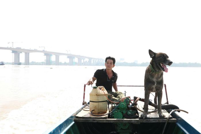 "Người hùng" lênh đênh trên sông Đồng Nai cùng người bạn nhỏ của mình. Ảnh: Trang Thư.