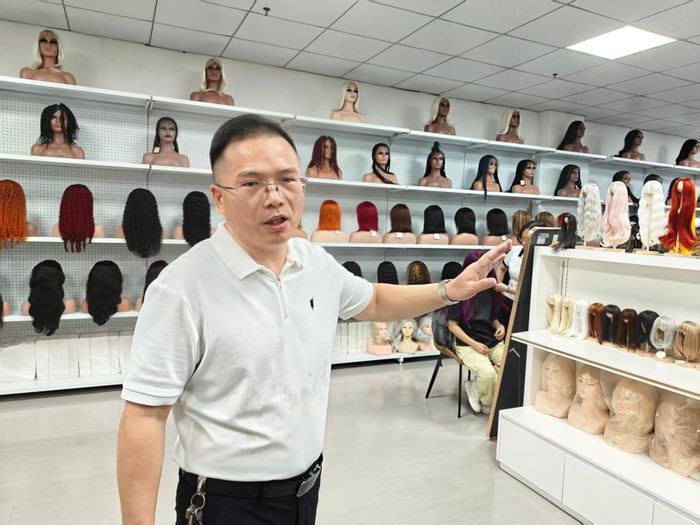 Tian Liangjun giới thiệu các mẫu tóc giả dành cho khách hàng nước ngoài tại Triển lãm Tóc Xuchang ở Hứa Xương, tỉnh Hà Nam. Ảnh: Cheng Ting/The Paper.