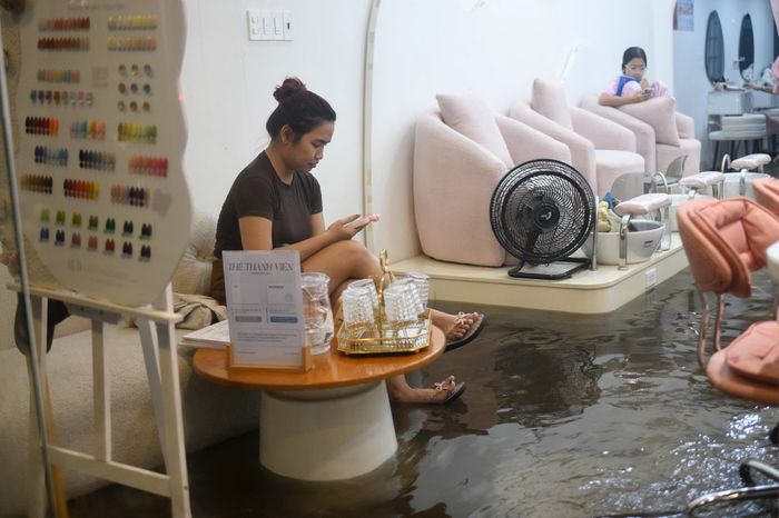  Nước tràn vào một tiệm nail gây ngập lênh láng khắp sàn. Người trong nhà bất lực đành ngồi chờ nước rút mới có thể dọn dẹp.