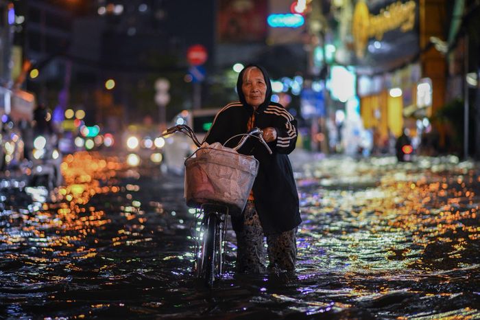  Bà Mai, cư dân sinh sống trong hẻm 172 Điện Biên Phủ, lội qua đoạn ngập để về nhà. Bà cho biết đây là lần đầu nước dâng cao đến vậy tại đoạn đường này. 