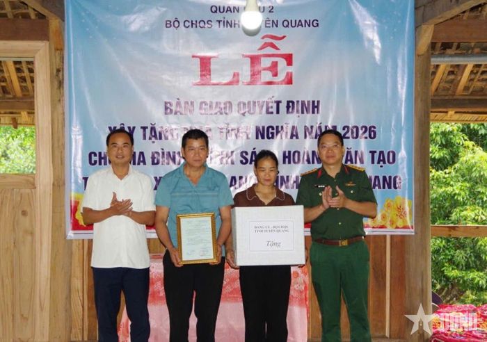 Đại diện Bộ CHQS tỉnh Tuyên Quang bàn giao quyết định xây nhà tình nghĩa và trao quà tặng vợ chồng ông Hoàng Văn Tạo. Ảnh: ĐĂNG NINH
