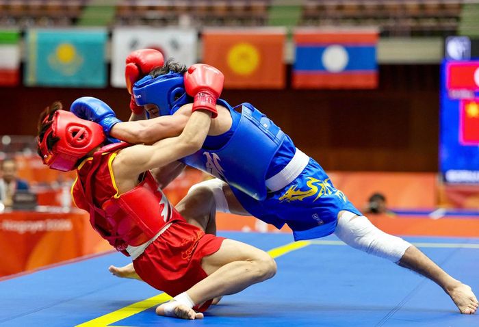Võ sĩ Đinh Văn Tâm (giáp xanh) phải băng hai chân vì chấn thương nhưng thi đấu đầy quyết tâm ở chung kết hạng 56kg nam tán thủ, môn wushu. Ảnh: ĐỘC LẬP 