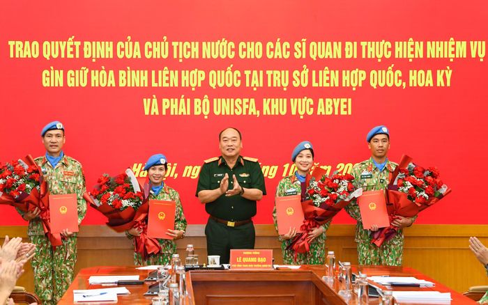  Thượng tướng Lê Quang Đạo trao quyết định của Chủ tịch nước cho 4 sĩ quan nhận nhiệm vụ. Ảnh: P.S 