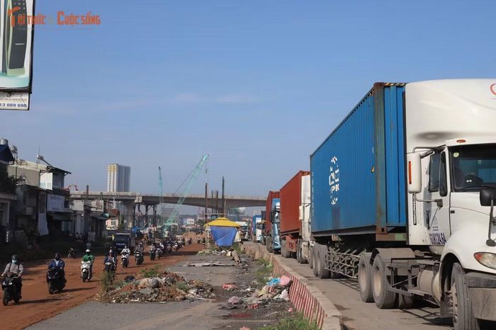 Xe đầu kéo container xếp hàng dài từ khu vực cầu Đồng Nai, nhiều tài xế phải kiên nhẫn chờ đến lượt vào cảng.
