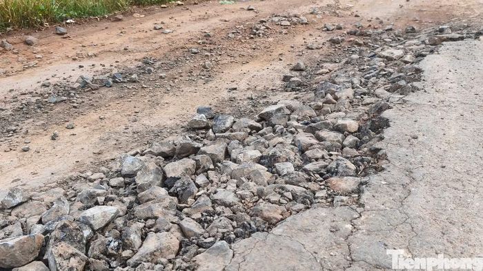 Mặt đường nhựa bị đứt gãy, đá trồi lên lởm chởm.