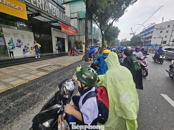 Thời điểm này cũng trùng với giờ học sinh tan trường. Một số phụ huynh chủ động dừng xe bên đường, mặc áo mưa và chờ mưa giảm trước khi tiếp tục di chuyển. Nhiều người cho biết lo con bị ướt mưa, ảnh hưởng sức khỏe nên tranh thủ tìm chỗ trú.