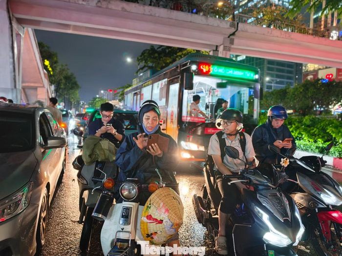 Nhiều người gọi điện thoại về nhà báo cho người thân vì không biết đến khi nào mới thoát khỏi điểm kẹt. Ảnh: Khoa Nam