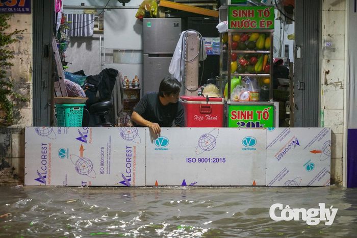 Người dân dùng các vật dụng để ngăn nước tràn vào nhà.
