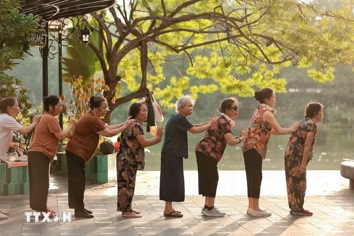 Nhóm phụ nữ cao tuổi phối hợp thực hiện bài tập vận động, tạo không khí vui tươi và gắn kết trong sinh hoạt cộng đồng.(Ảnh: Phạm Tuấn Anh/TTXVN)