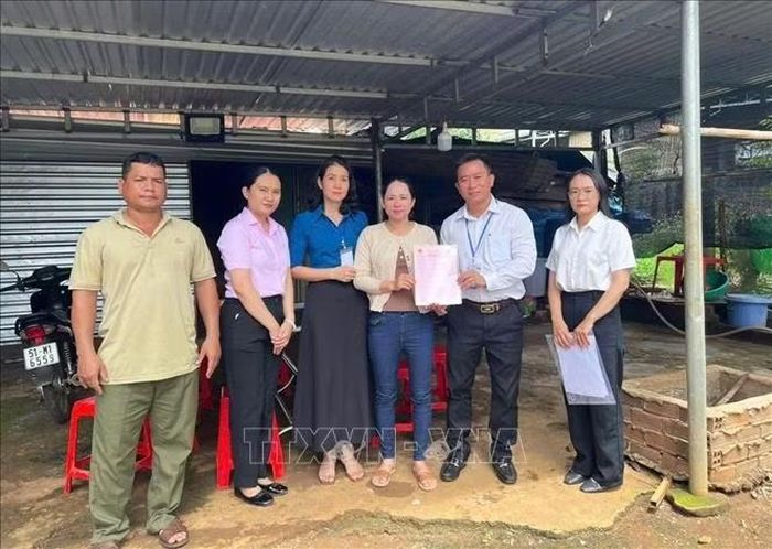 Phó Chủ tịch UBND xã Bù Đăng Nguyễn Cảnh Thảo trao giấy chứng nhận quyền sử dụng đất lần đầu tận nhà cho bà Lê Thị Nga, thôn Đức Thọ, xã Bù Đăng.