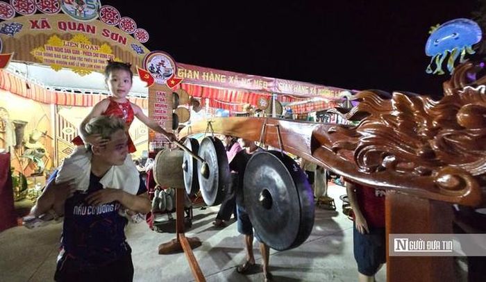 Bé gái rất thích thú khi được trải nghiệm không gian văn hóa đồng bào vùng cao tại liên hoan.
