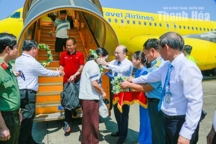 Phó Chủ tịch UBND tỉnh Cao Văn Cường và các đại biểu tặng hoa chúc mừng những hành khách đầu tiên trong chuyến bay.
