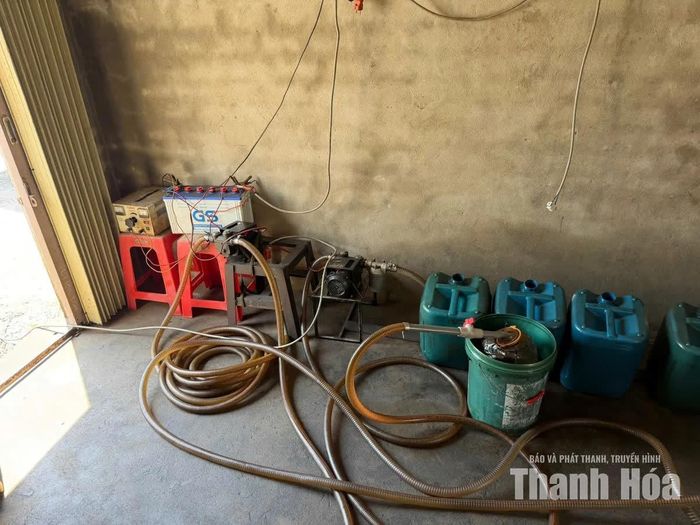 Công cụ hút dầu từ bể chứa tại kho phế liệu.