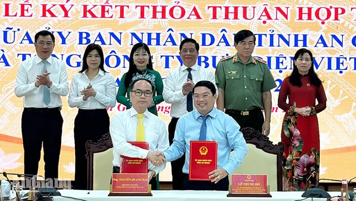 Ủy viên Ban Thường vụ Tỉnh ủy, Phó Chủ tịch UBND tỉnh An Giang Lê Trung Hồ (bên phải) và Phó Tổng Giám đốc Tổng Công ty Bưu điện Việt Nam Nguyễn Quang Hải ký thỏa thuận hợp tác.