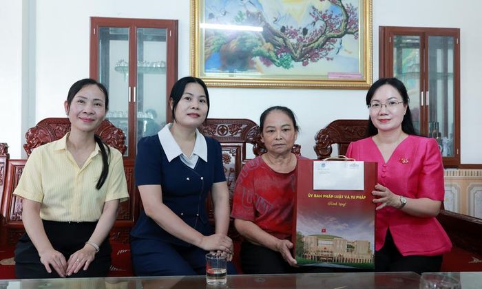 Đồng chí Đỗ Thị Việt Hà cùng lãnh đạo Đảng ủy xã Nam Dương tặng quà bà Tô Thị Lan.