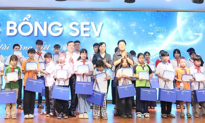 Đồng chí Nguyễn Thị Hà cùng lãnh đạo Hội Khuyến học thành phố và Công ty Samsung Electronics Việt Nam trao quà cho học sinh.