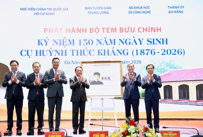 Các đại biểu chụp ảnh lưu niệm với tranh tem kỷ niệm 150 năm ngày sinh cụ Huỳnh Thúc Kháng. Ảnh: T.HUY - T.CÔNG