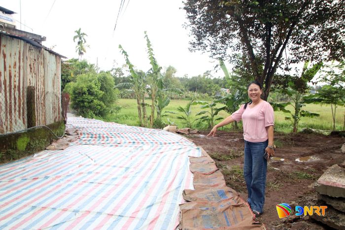 Bà Nguyễn Thị Kim Mai bên đường dân sinh vừa thảm bê tông. Ảnh: HÀN NGUYÊN