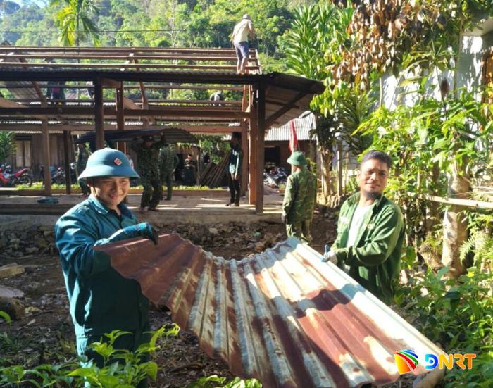 Lực lượng Ban Chỉ huy Quân sự và dân quân tự vệ xã Avương hỗ trợ ngày công giúp xóa nhà tạm, nhà dột nát cho các hộ dân. Ảnh: ĐVCC