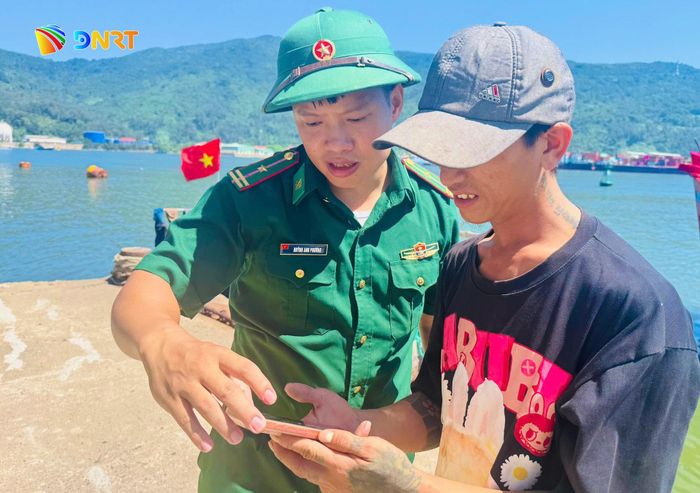 Cán bộ Đồn Biên phòng Sơn Trà hướng dẫn ngư dân khai báo trên ứng dụng eCDT. Ảnh: HUỲNH CHÍN