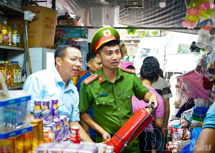 Cán bộ Đội Chữa cháy và CNCH khu vực Na Sang tuyên truyền đến hộ kinh doanh về công tác PCCC.