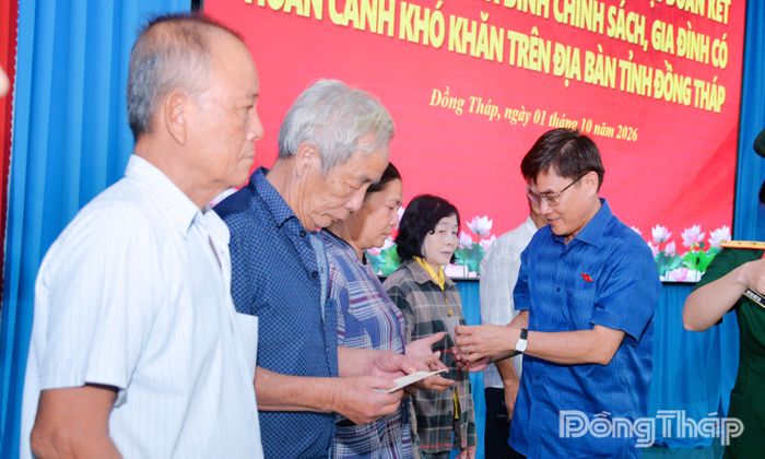 Đồng chí Nguyễn Văn Mười trao quà cho các gia đình chính sách, gia đình có hoàn cảnh khó khăn.