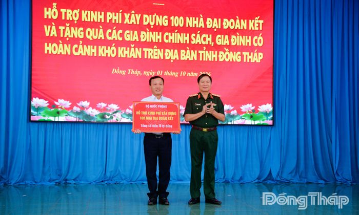 Đại tướng Nguyễn Tân Cương trao bảng tượng trưng hỗ trợ kinh phí xây dựng nhà Đại đoàn kết cho đại diện Ủy ban Mặt trận Tổ quốc Việt Nam tỉnh Đồng Tháp.