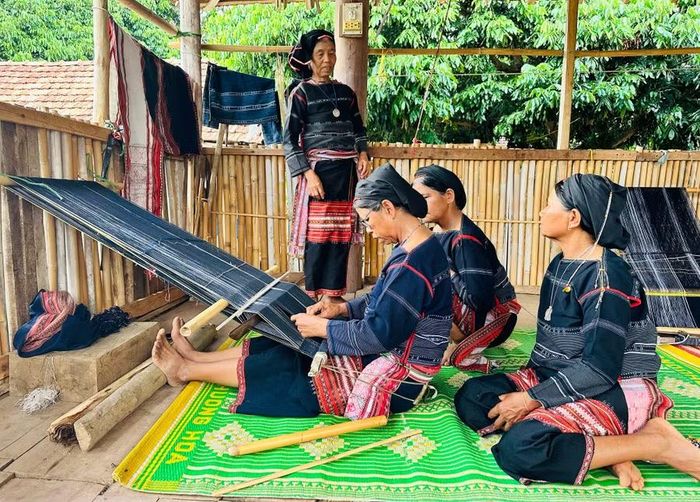Tranh thủ lúc nông nhàn, các nghệ nhân ở làng Kgiang cùng gặp gỡ, vừa trò chuyện vừa hướng dẫn nhau dệt thổ cẩm. Ảnh: D.Đ