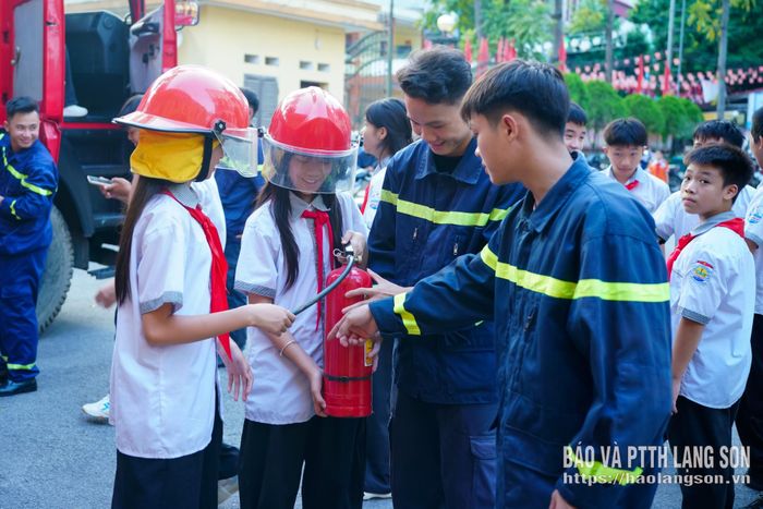 Các em học sinh được hướng dẫn, trải nghiệm thiết bị chữa cháy trong chương trình