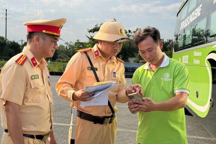 Cán bộ, chiến sĩ Đội 1, Phòng 6, Cục Cảnh sát giao thông kiểm tra kết nối camera hành trình trên xe khách với các thiết bị khác.