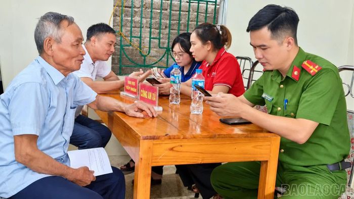 Cán bộ Công an xã Thác Bà hỗ trợ người dân nâng cấp tài khoản VNeID mức độ 2.