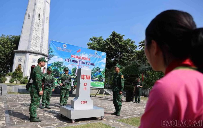 Học sinh dõi theo Bộ đội Biên phòng thực hành bên mô hình cột mốc. Bài học về bảo vệ biên giới được truyền đạt qua từng động tác cụ thể.